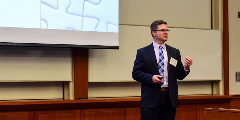 Faculty member presenting research to audience.