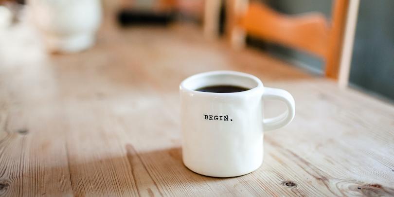 coffee cup with the word "begin" on it.