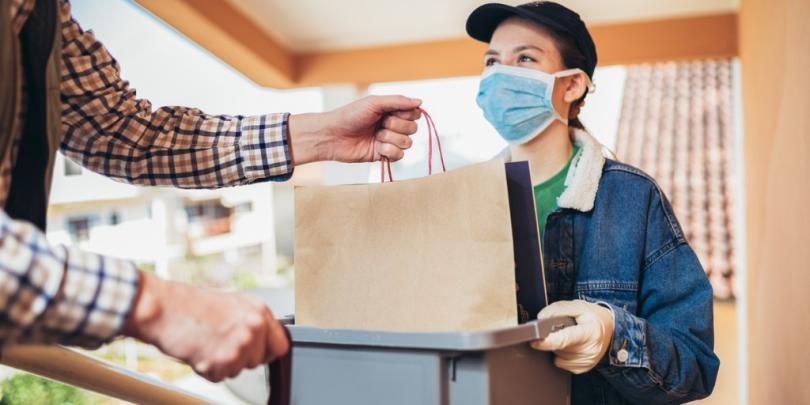 Woman with mask on delivering food