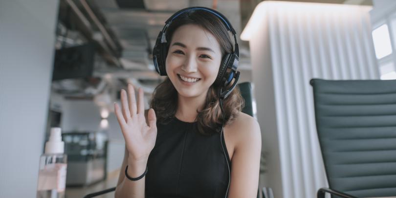 Woman waving hi to camera