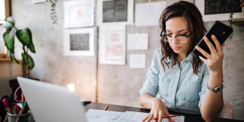 Woman at computer and looking at papers