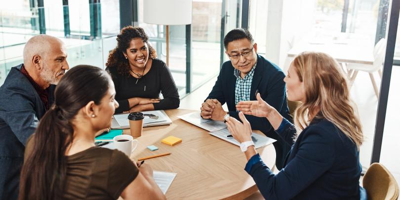 Diverse group of people at a table talking