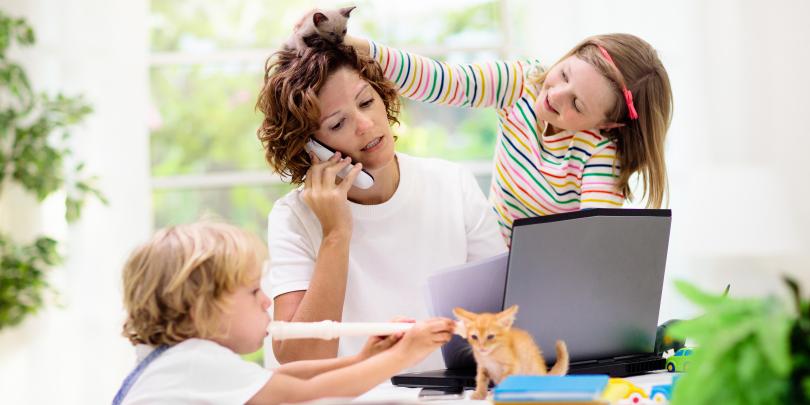 Mom working from home with kids all over her