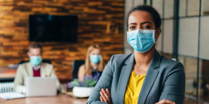 Business-people working with face masks in office