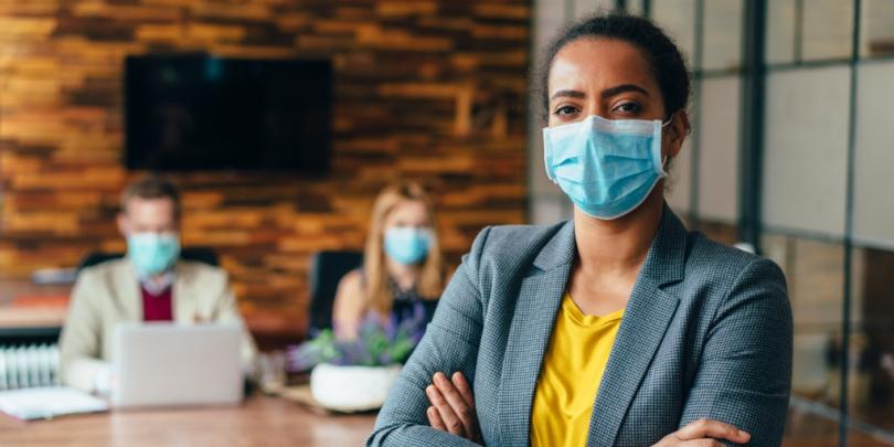 Business-people working with face masks in office