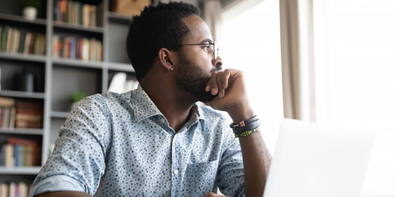 Man at laptop looking thoughtful