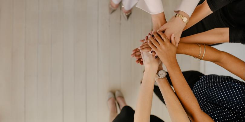 Women putting their hands together in solidarity