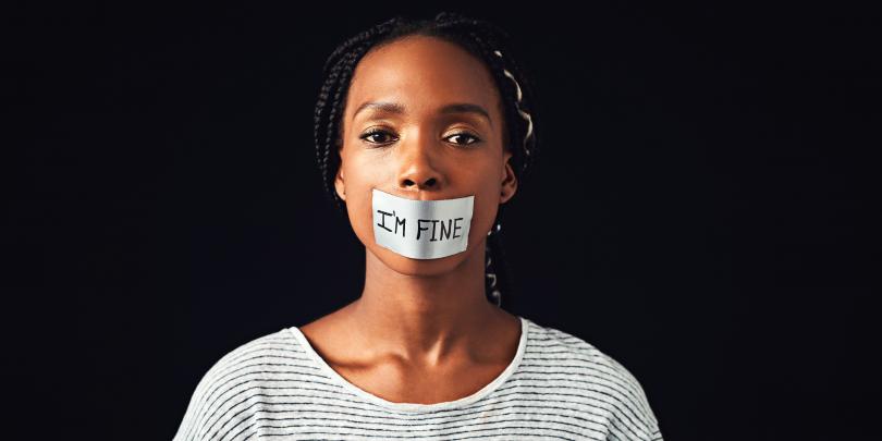 Woman with tape on her mouth that states "I'm fine"