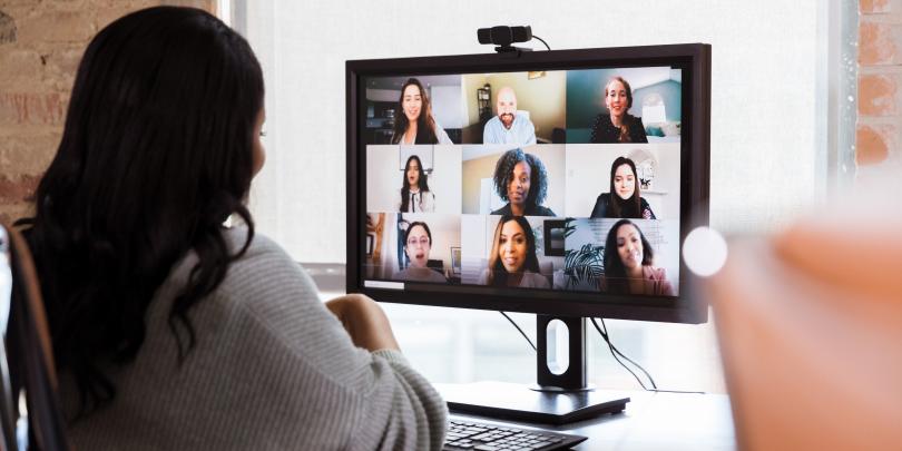 Woman looking at coworkers on computer screen