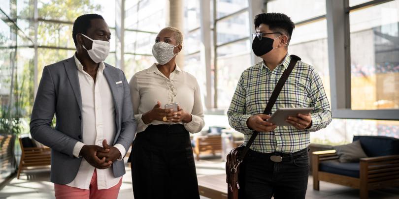 Three people walking with masks on