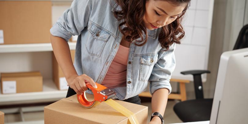 Woman taping up a package for delivery