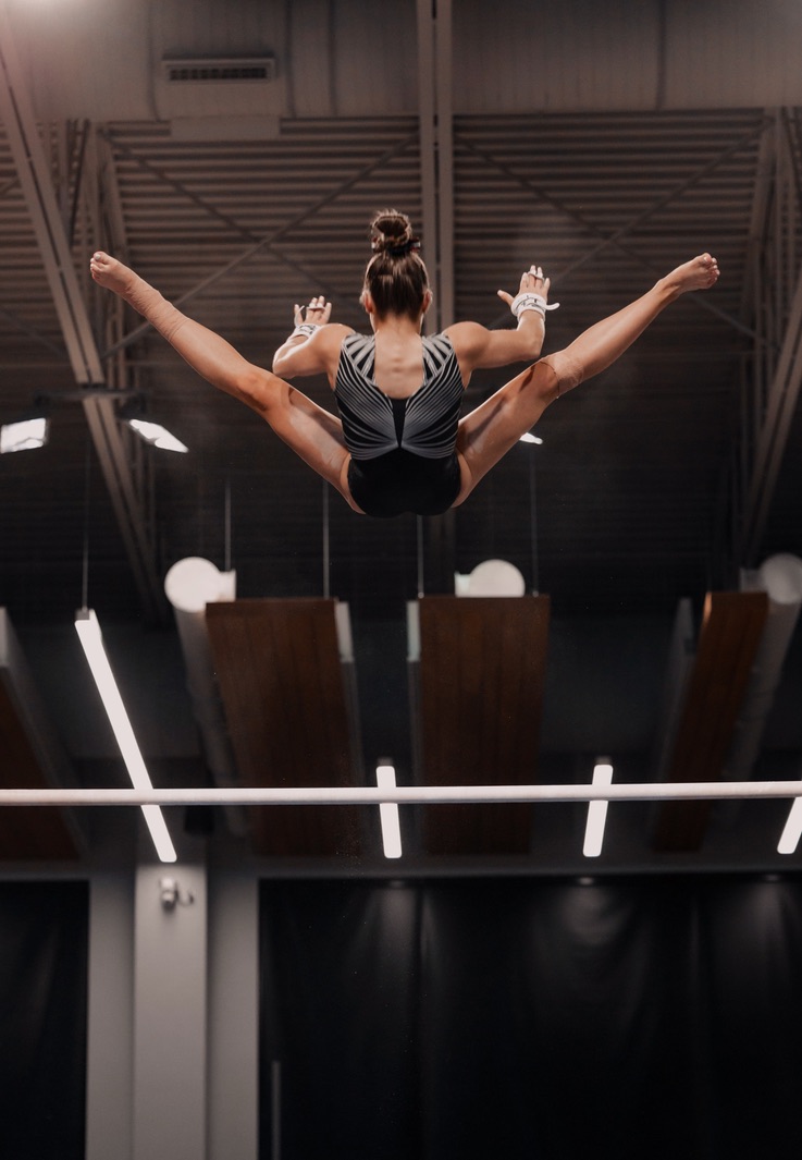 Fisher finance student Nicole Riccardi flying off the high bars.