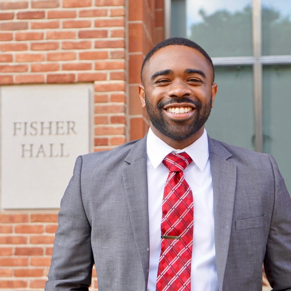 Dominique Mosbly professional headshot next to Fisher College of Business sign