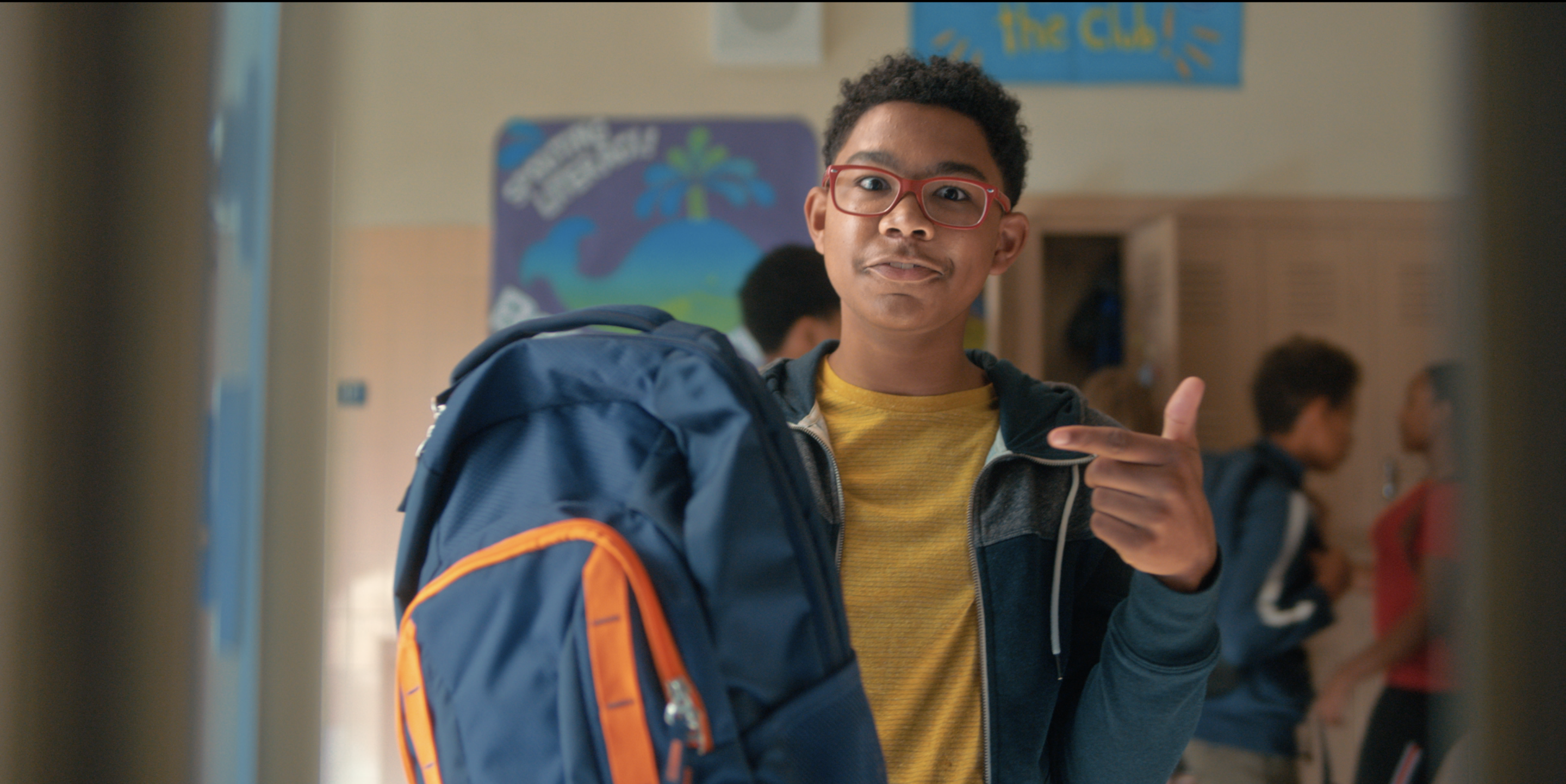 young child holding and pointing to his backpack