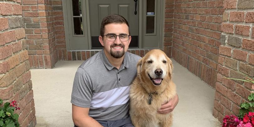 Nick Lenyo and dog on front porch of home